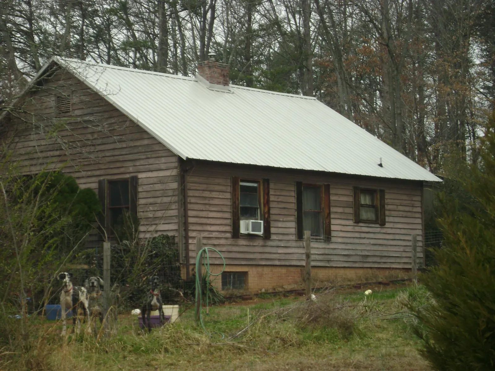 White metal roof on an old wood sided farmhouse, from a Metal Roof Installation job in River Ranch